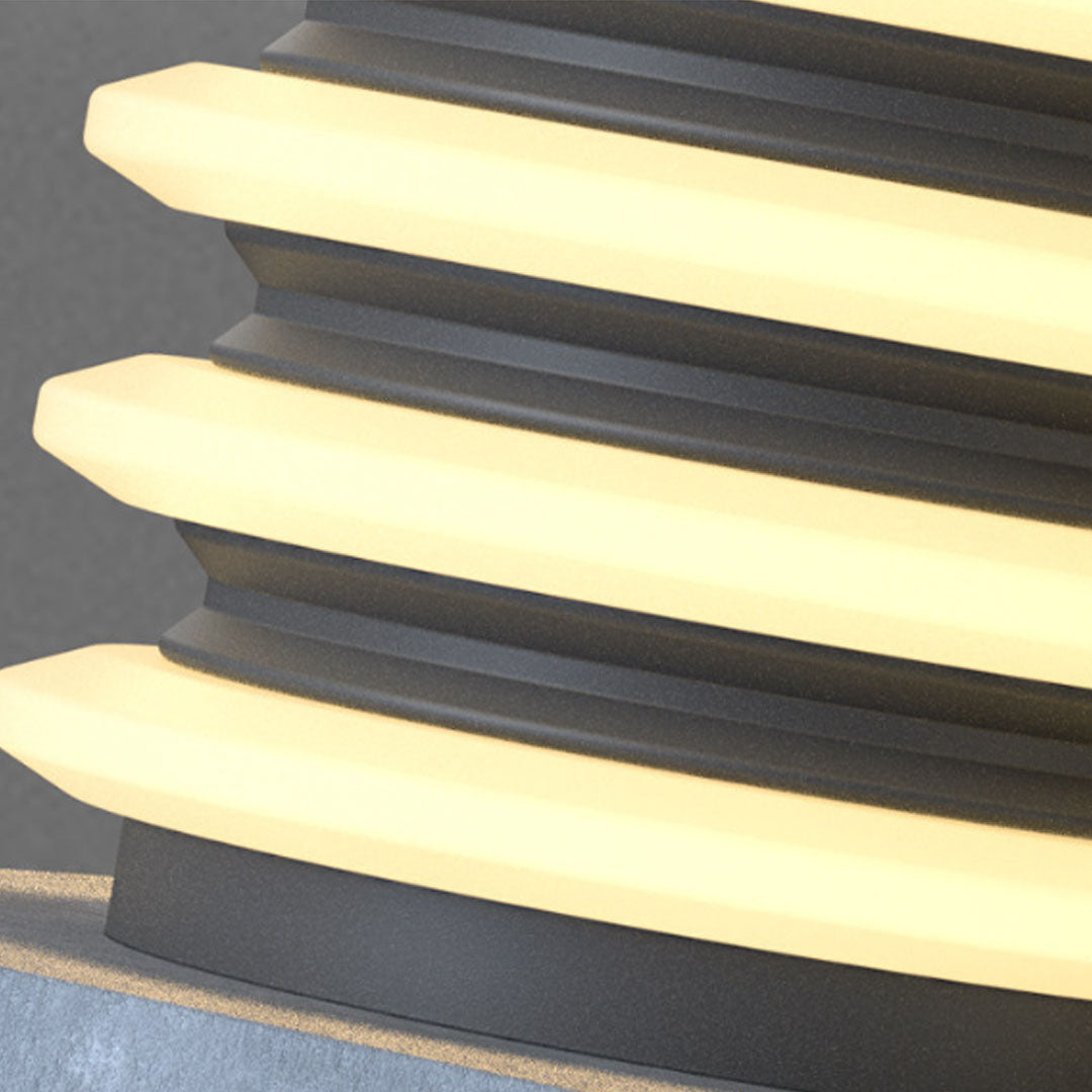 Close-up detail of solar garden pillar lights showing layered illuminated ring structure and finish.