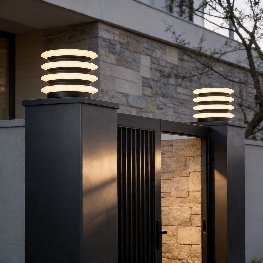 Solar garden pillar lights installed on modern exterior pillars with warm ambient evening glow.