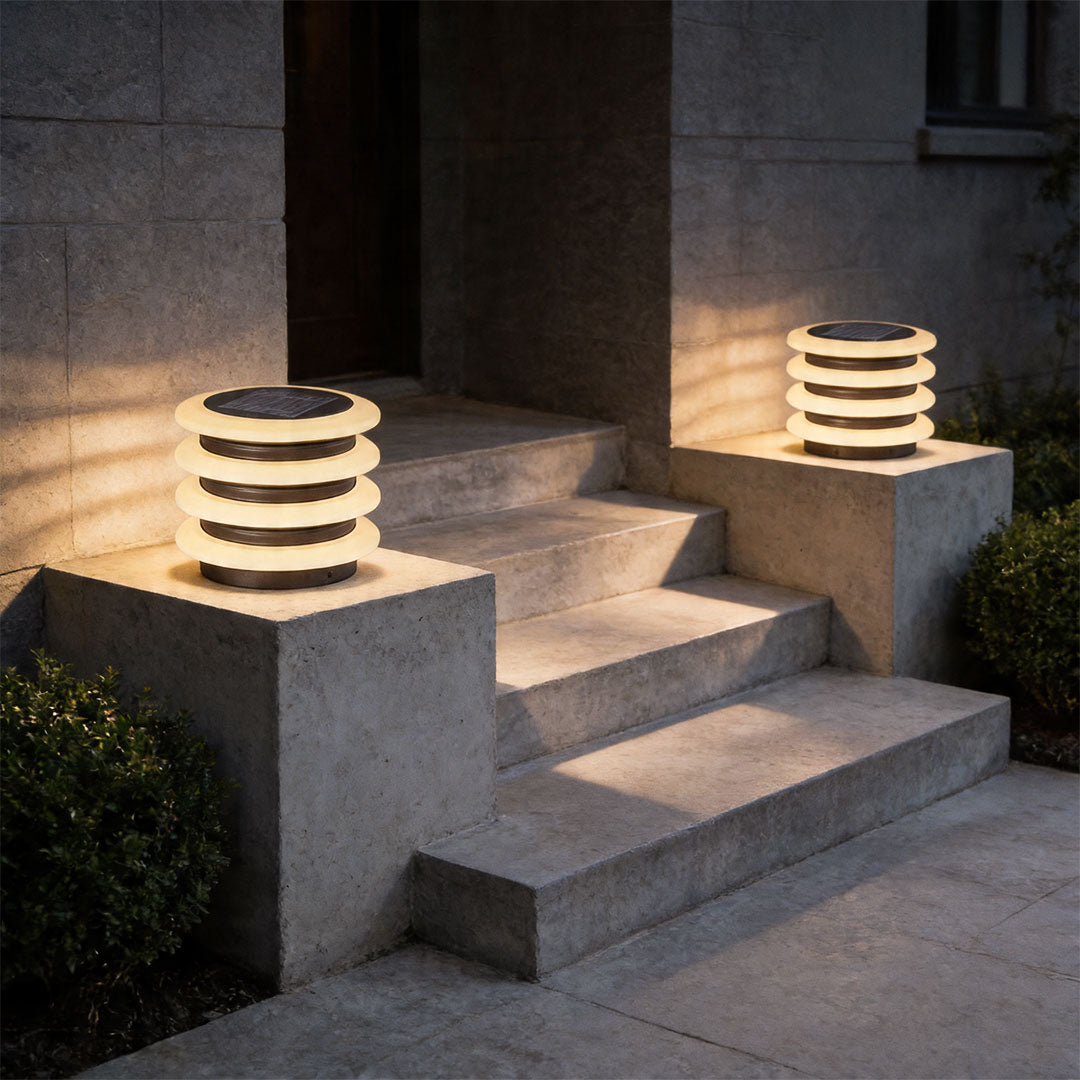 Solar garden pillar lights beside outdoor stairs providing stylish landscape illumination at night.
