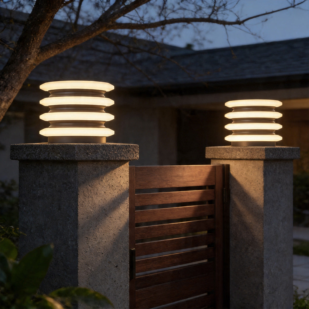 Solar garden pillar lights mounted on stone gate posts creating elegant entrance pathway lighting.