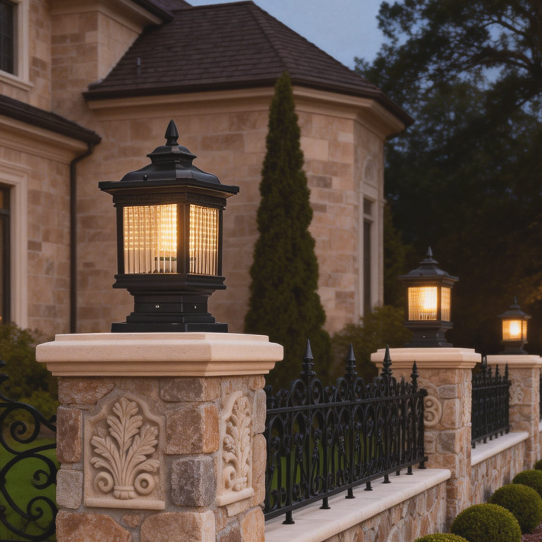 Solar garden post lights mounted along a decorative fence, illuminating a classic garden walkway at dusk.