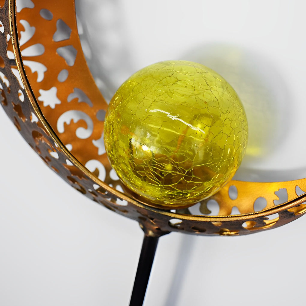 Close-up of a solar garden stake light with a crackle glass globe inside a perforated metal shade.