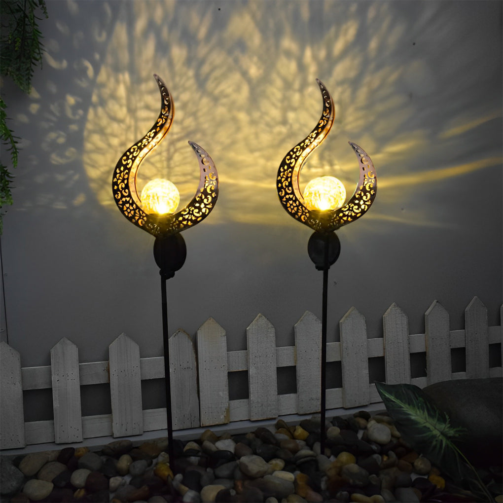 Solar garden stake lights with flame-shaped shades creating warm decorative patterns on an exterior wall.