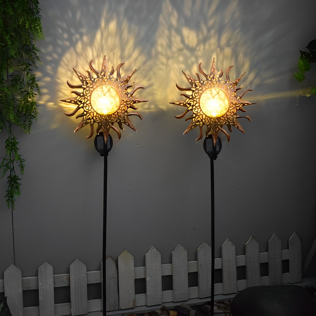 Solar garden stake lights with sun-shaped metal shades casting bright decorative patterns at night.