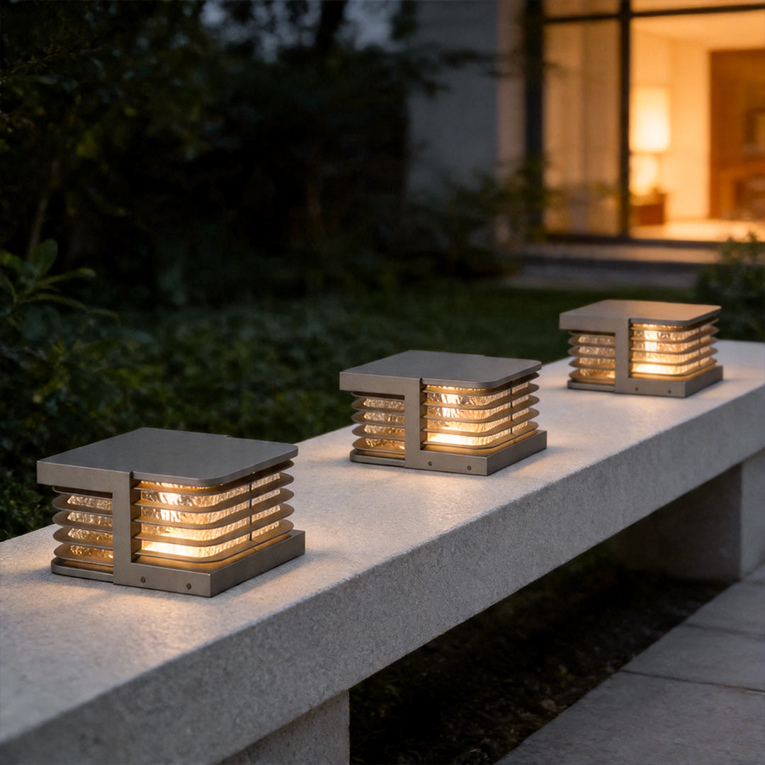 Solar gate pillar lights arranged along outdoor bench wall with stylish layered lighting design.