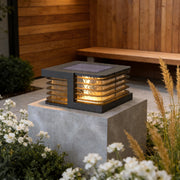Solar gate pillar lights installed on concrete garden wall with warm decorative outdoor illumination.