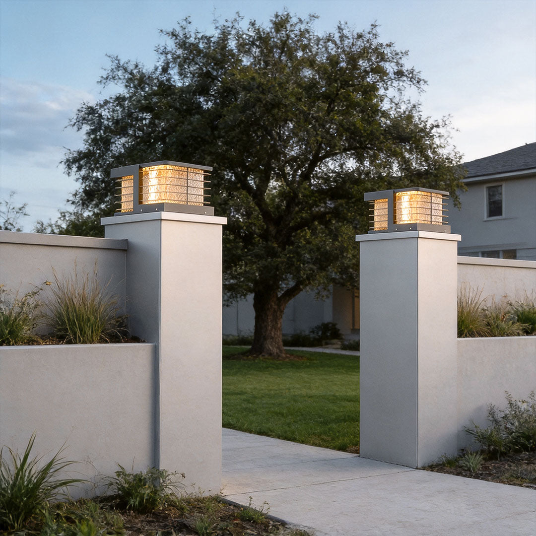 Solar gate pillar lights mounted on tall entrance columns creating elegant modern landscape lighting.
