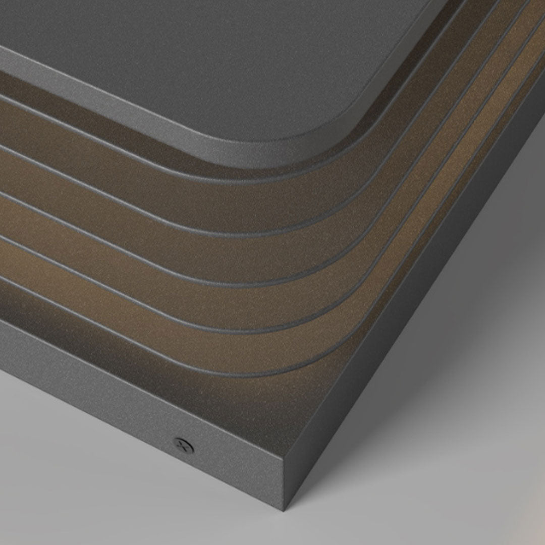 Close-up detail of solar gate pillar lights showing textured layered metal frame and finish.