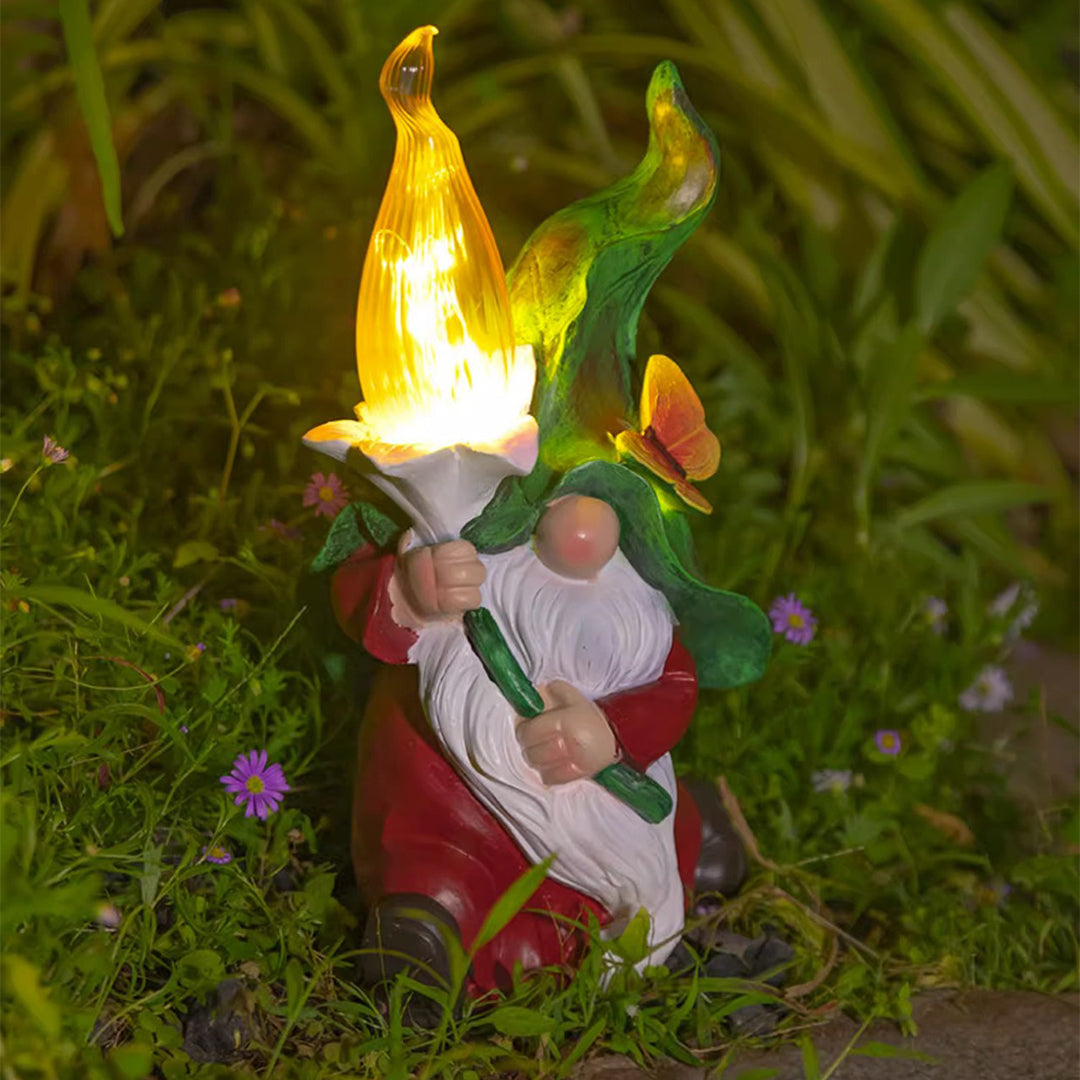 Solar gnomes garden lights in a garden with a gnome holding a glowing flower.