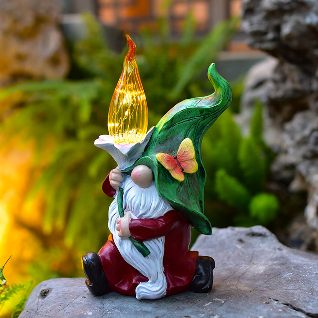 Solar gnomes garden lights casting a warm glow with a gnome holding a yellow flame.