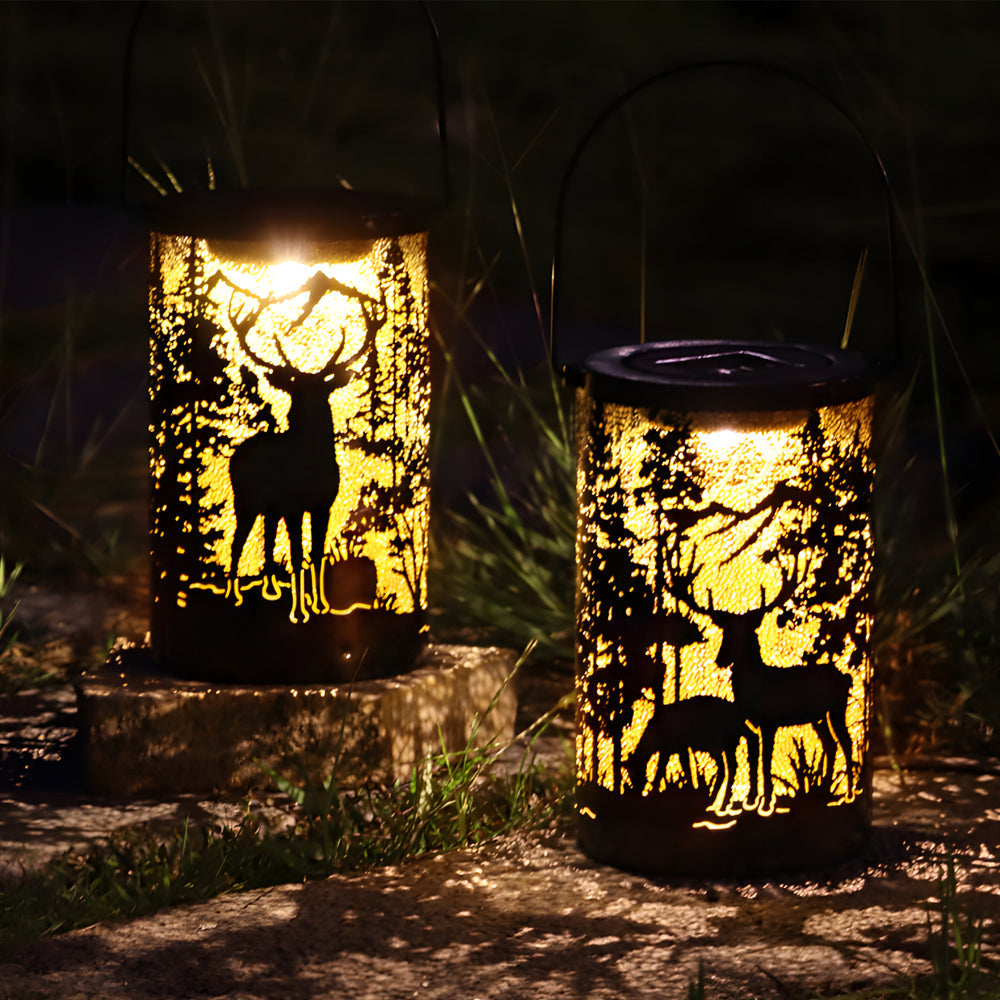 Solar hollow out lantern with deer silhouette, glowing warmly in a dark outdoor setting.