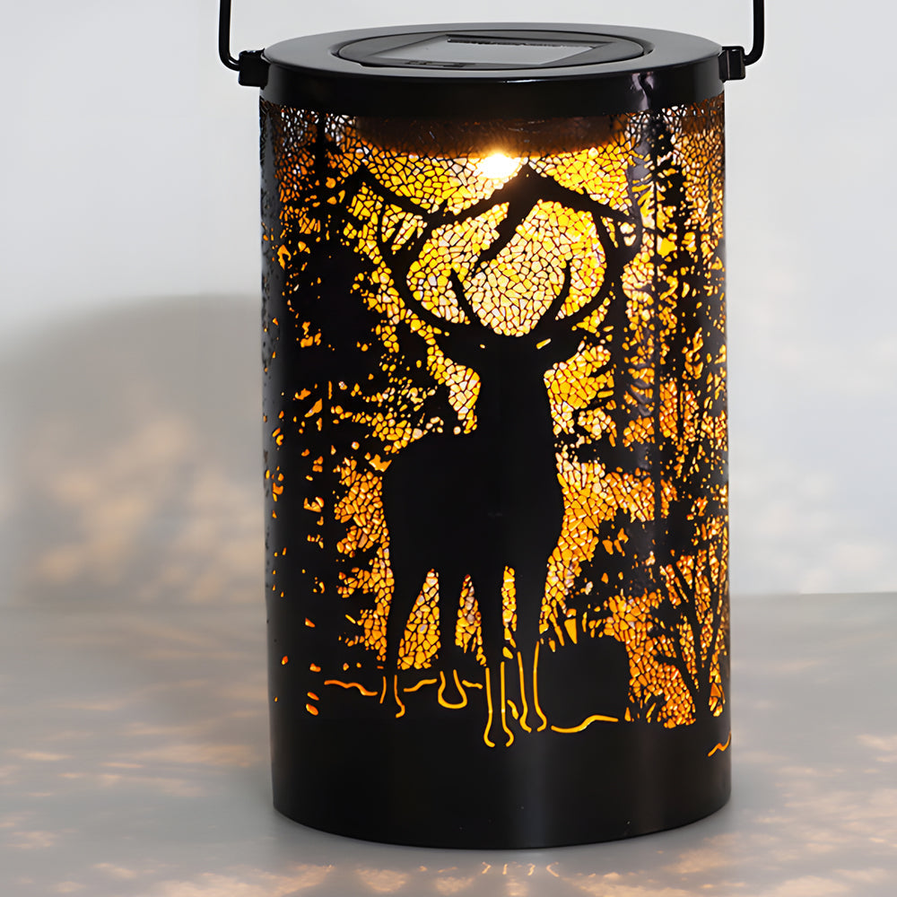 Solar hollow out lantern with deer design, glowing softly on a wooden surface.