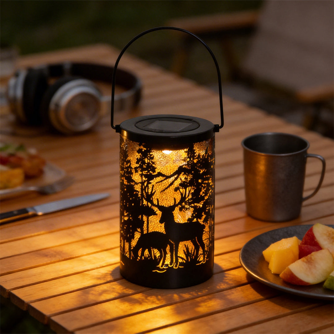Solar hollow out lantern with nature-themed cut-outs, placed on a wooden table with snacks.