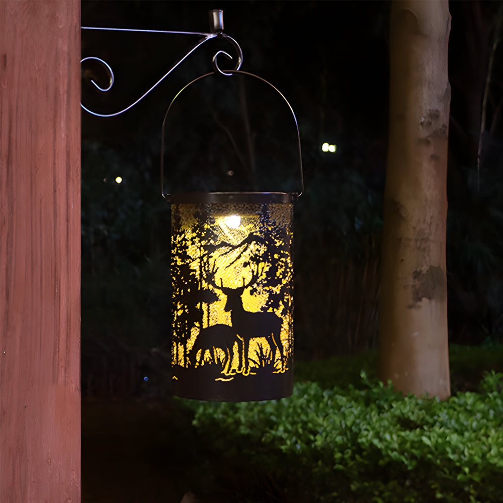 Solar hollow out lantern hanging on a tree branch, casting a warm glow in a garden.
