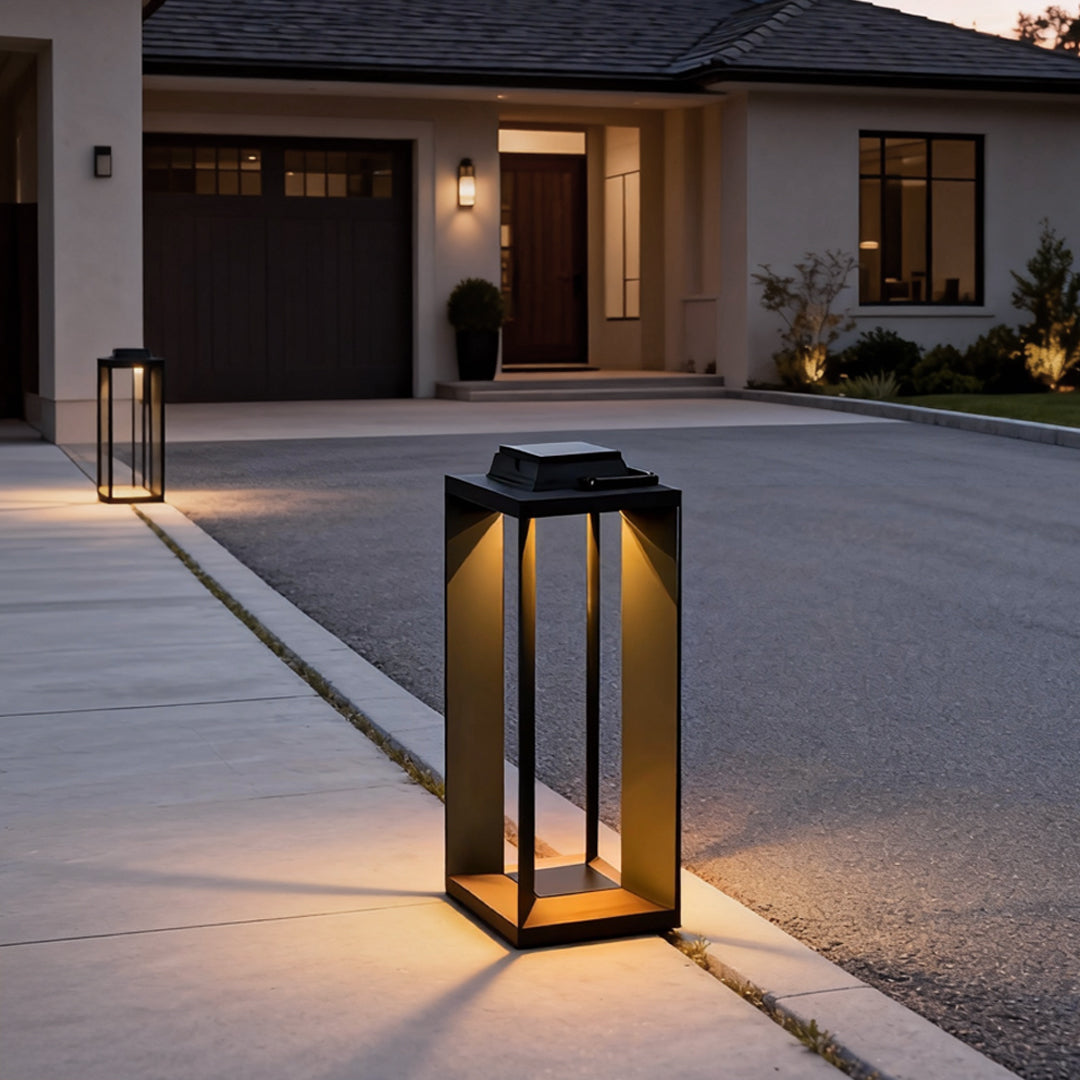 Modern portable solar lantern illuminating a residential driveway and entrance at dusk.
