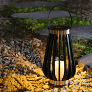 Solar garden lantern illuminating outdoor landscaping with warm ambient lighting at dusk