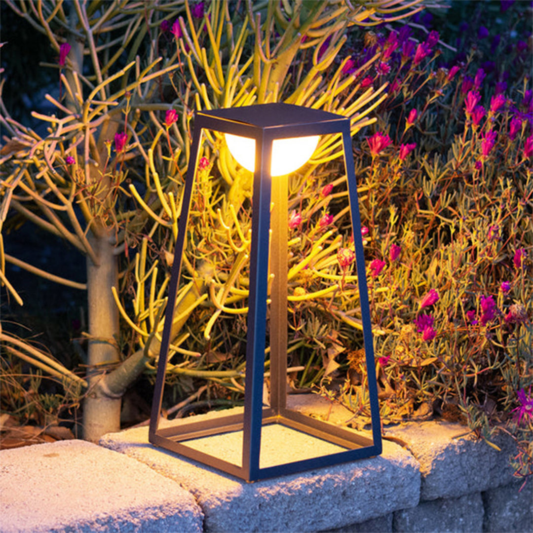 Solar-powered lantern illuminating vibrant tropical garden plants with warm evening glow