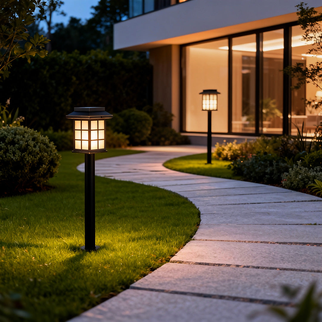 Modern solar led path lights illuminating a backyard pathway near a house entrance, combining energy efficiency and style.
