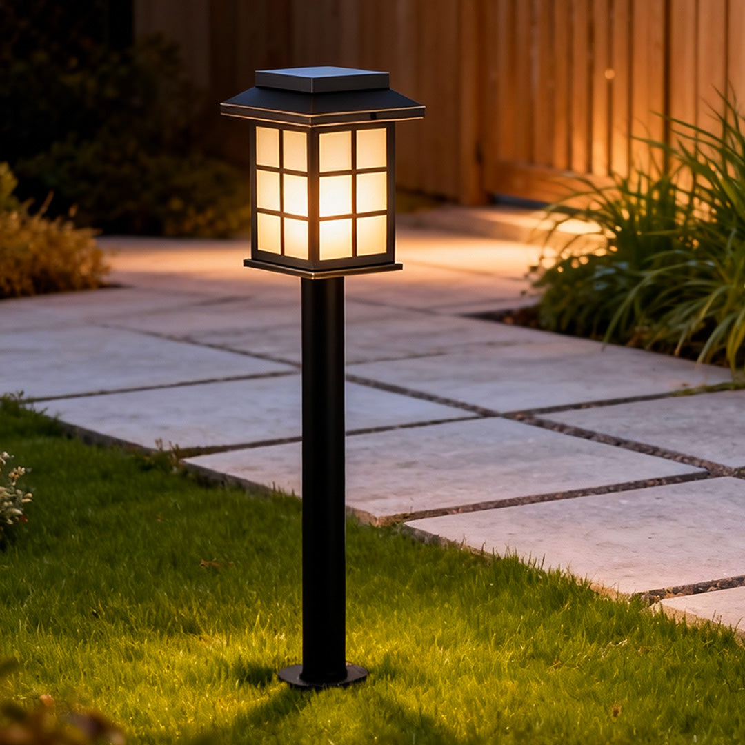 Solar led path lights placed beside stone paving and greenery, offering soft ambient lighting for residential landscape design.