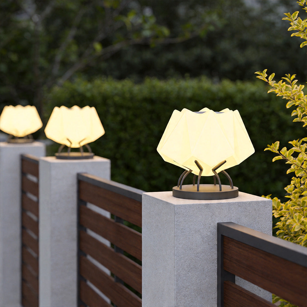 Solar led pillar lights mounted on garden wall pillars beside wooden fence at night.