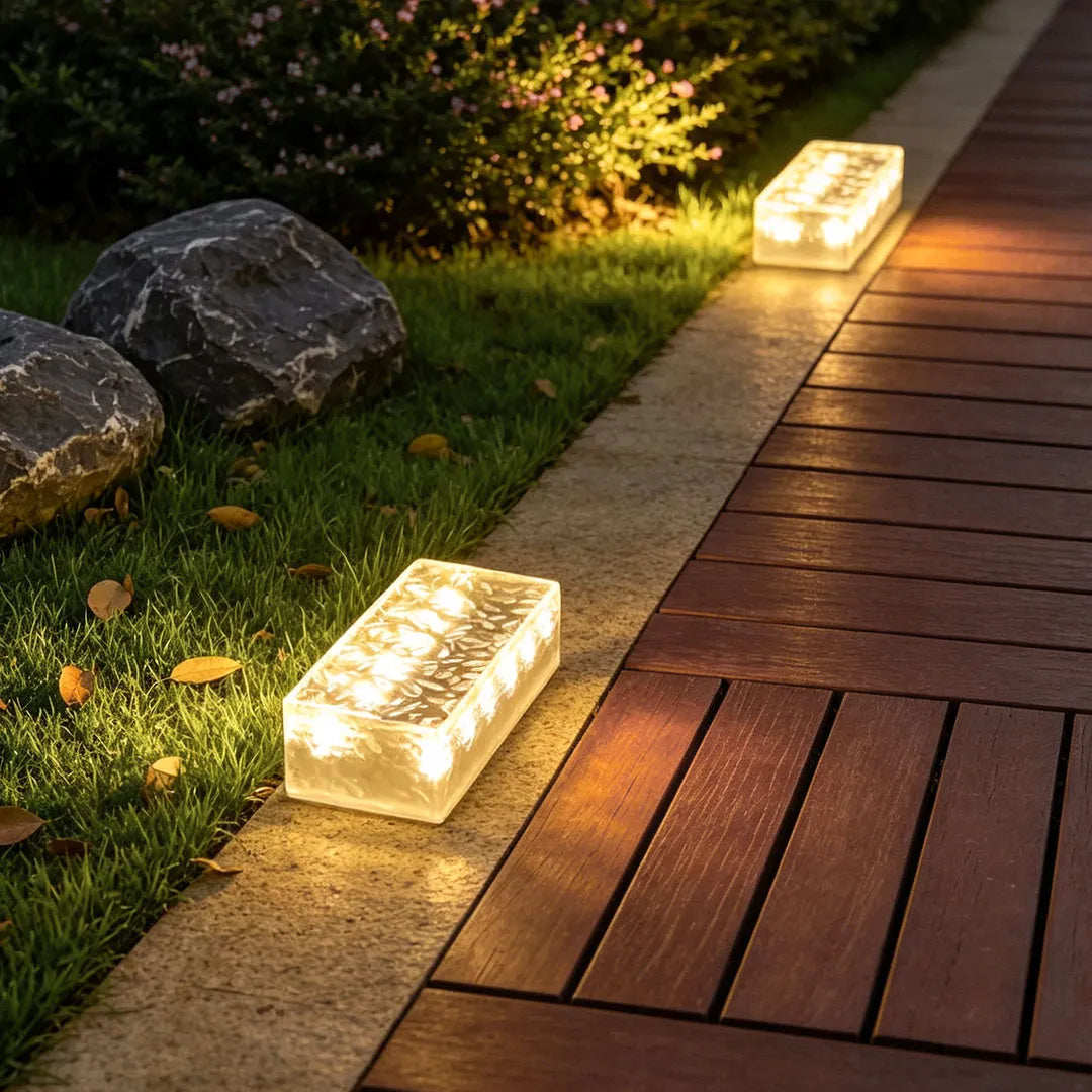 Solar LED step lights lining a deck edge and lawn border, creating warm pathway lighting.