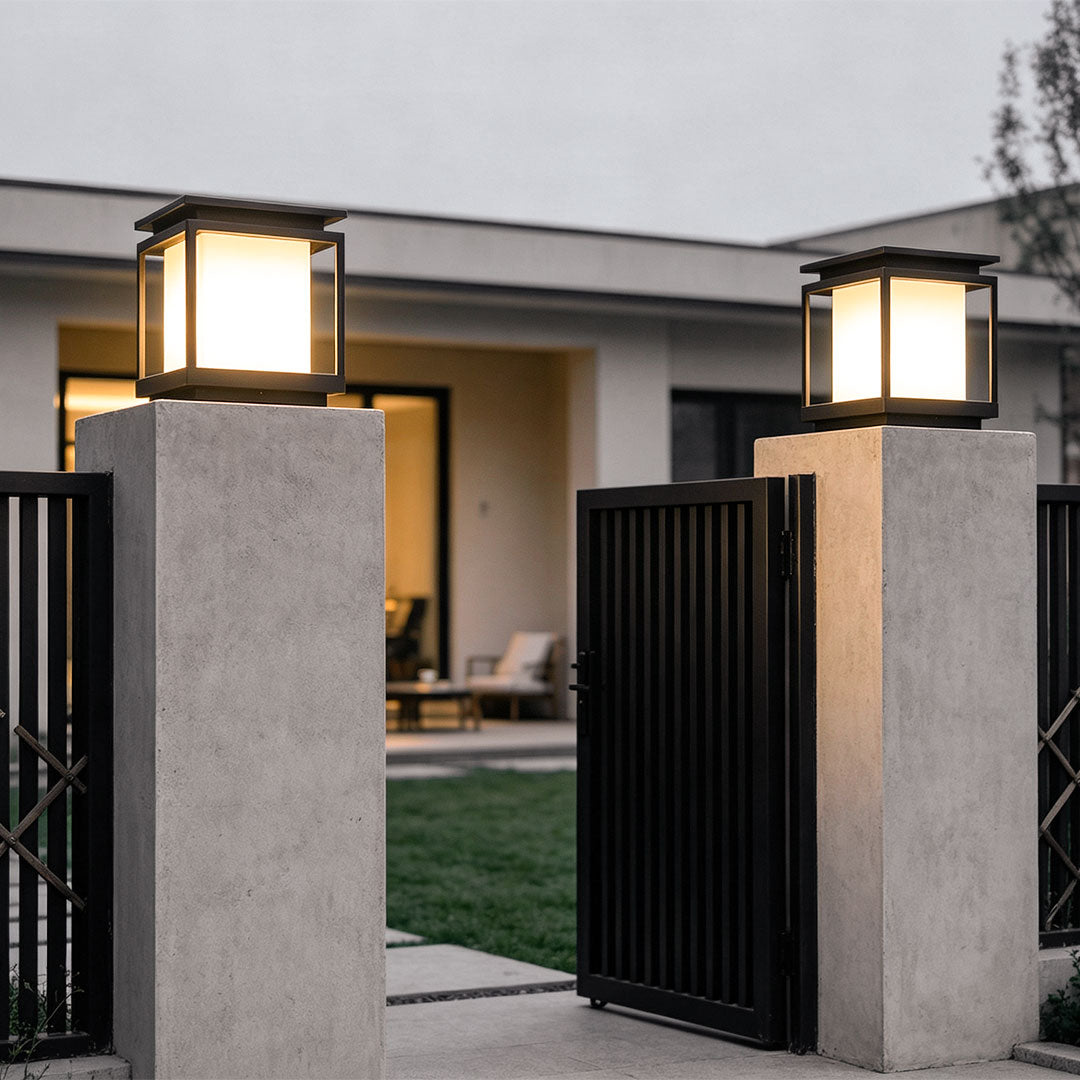 Modern solar light for main gate pillar installed on concrete entrance columns at luxury home driveway.