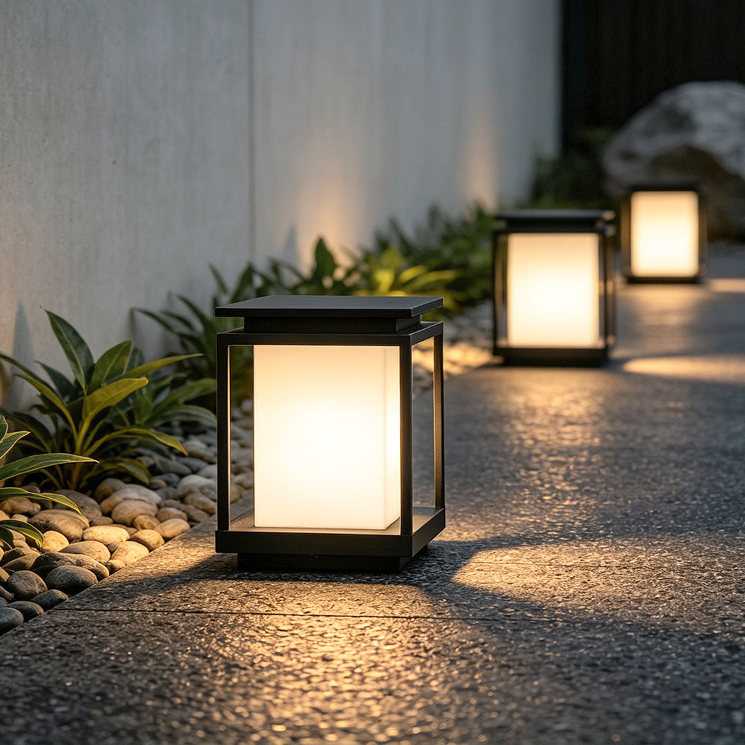 Modern solar light for main gate pillar installed on concrete entrance columns at luxury home driveway.