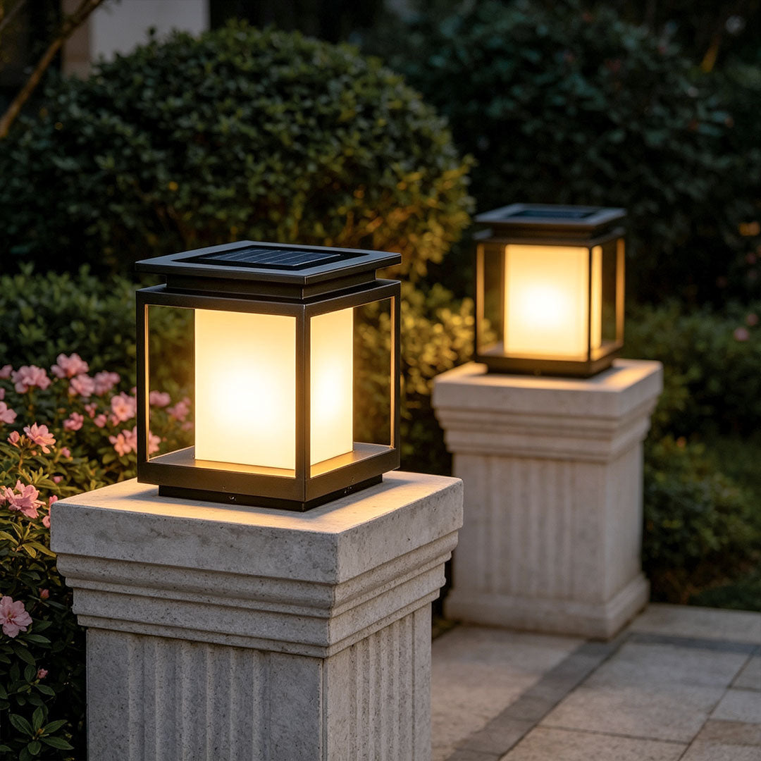 Modern solar light for main gate pillar installed on concrete entrance columns at luxury home driveway.