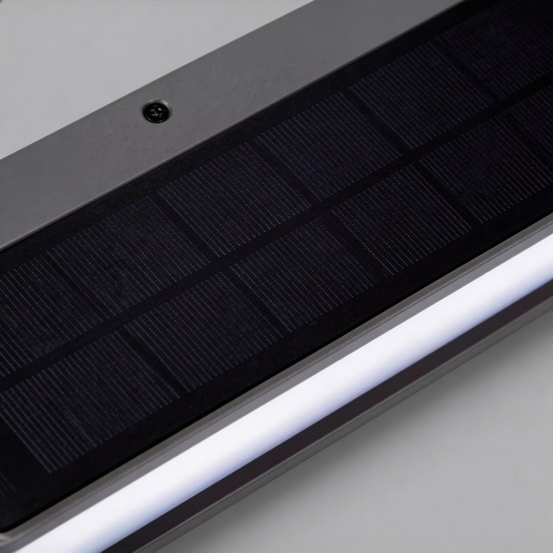 Solar light outdoor wall mount with a rectangular design, illuminating a modern house exterior.