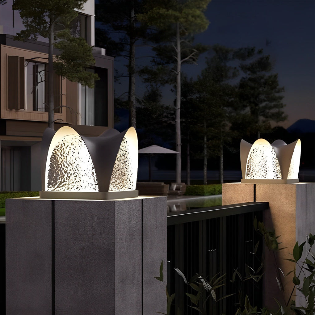 Solar light pillar with a black finish, installed on a stone base in a garden.