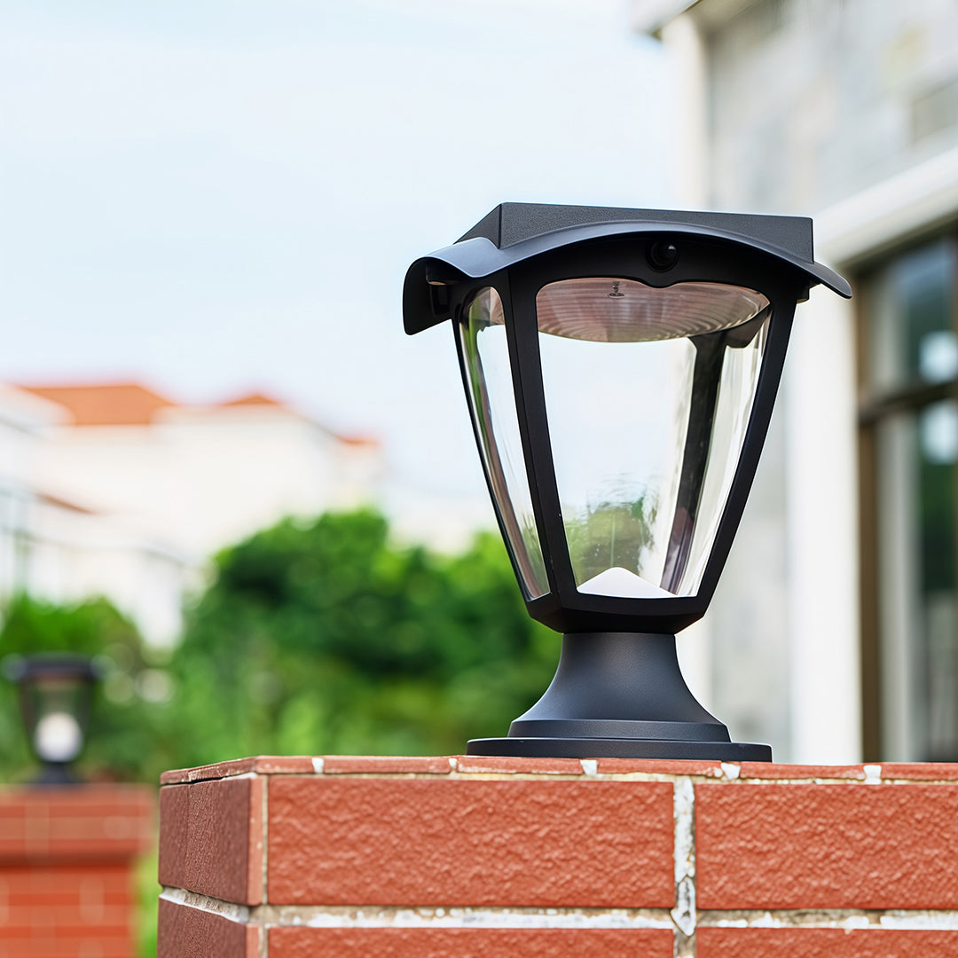 Daytime product shot of the solar light pillar with its curved solar panel top, installed on a brick fence.