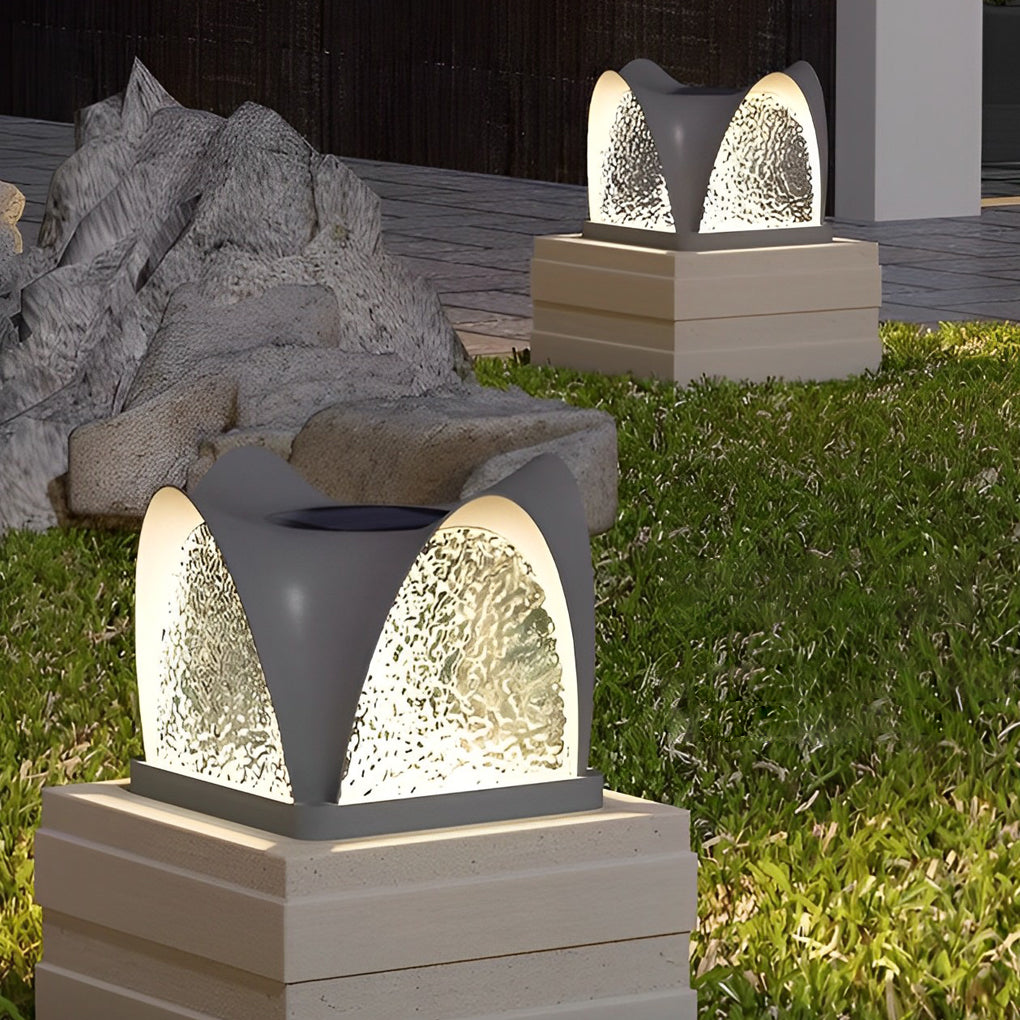 Solar light pillar with a textured surface, enhancing a garden pathway.