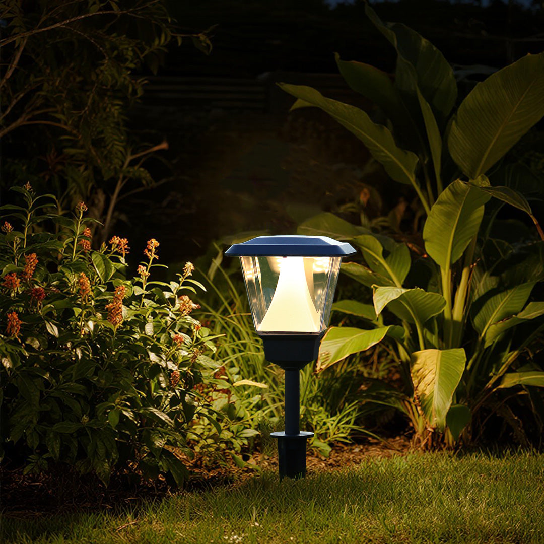 Solar garden light highlighting tropical plants and foliage in landscaped outdoor setting