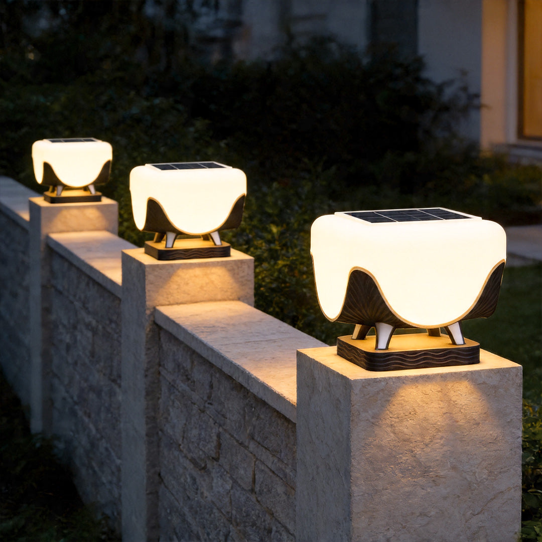 Solar lights for pillar tops mounted along garden wall creating elegant pathway lighting at night.