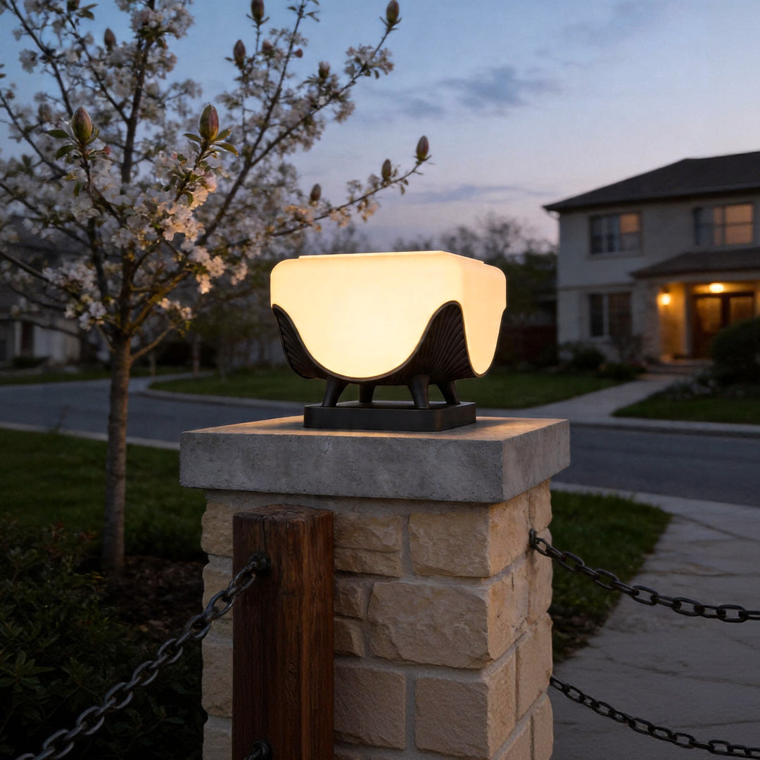 Solar lights for pillar tops illuminating stone entrance column with warm ambient evening glow.