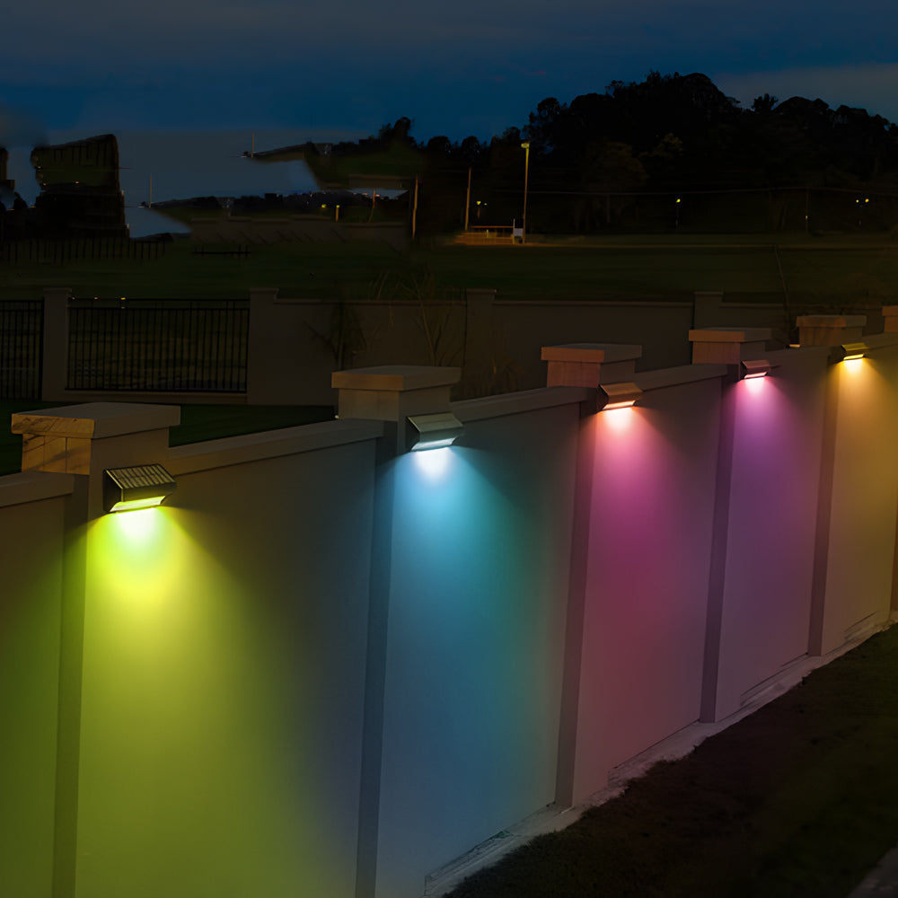 Color-changing solar outdoor wall lights dusk to dawn mounted on a garden wall for decorative outdoor lighting.