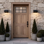 Solar outdoor wall lights dusk to dawn illuminating a rustic wooden door entrance with automatic evening activation.