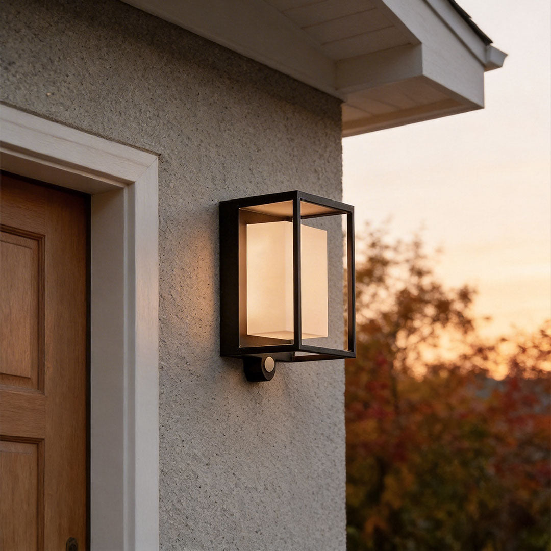 Solar outdoor wall mounted lights with a modern rectangular design, illuminating a house entrance at dusk.