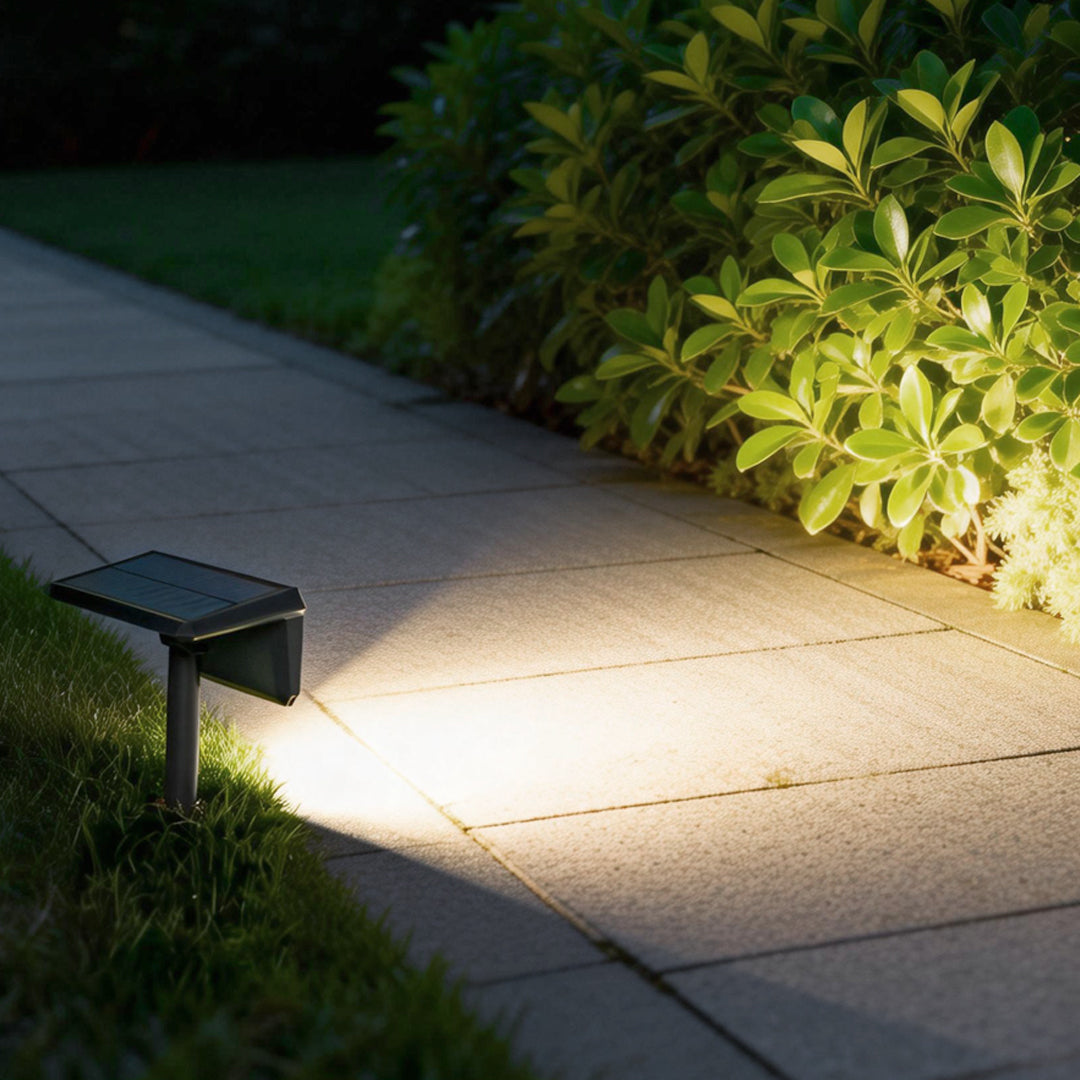 Solar path lights outdoor casting bright light along a concrete walkway, enhancing nighttime garden safety.