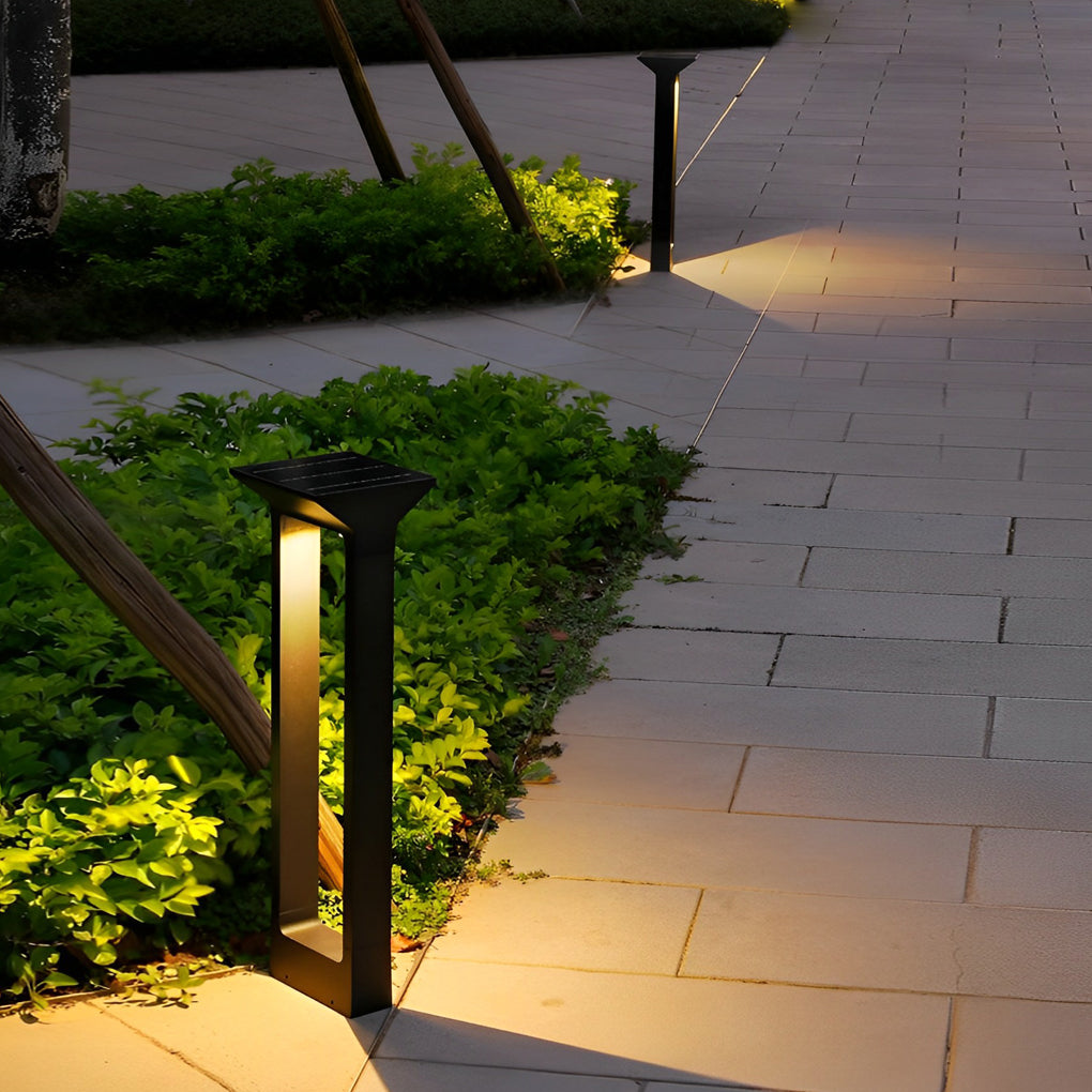 Solar pathway outdoor lamp installed along stone walkway with greenery borders.