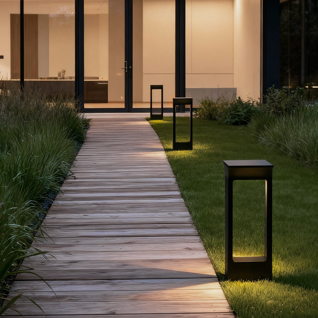 Modern solar pathway outdoor lamp illuminating a wooden garden walkway at night.