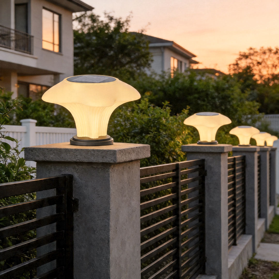 Solar pillar light installed on modern fence posts providing warm outdoor pathway illumination at sunset.