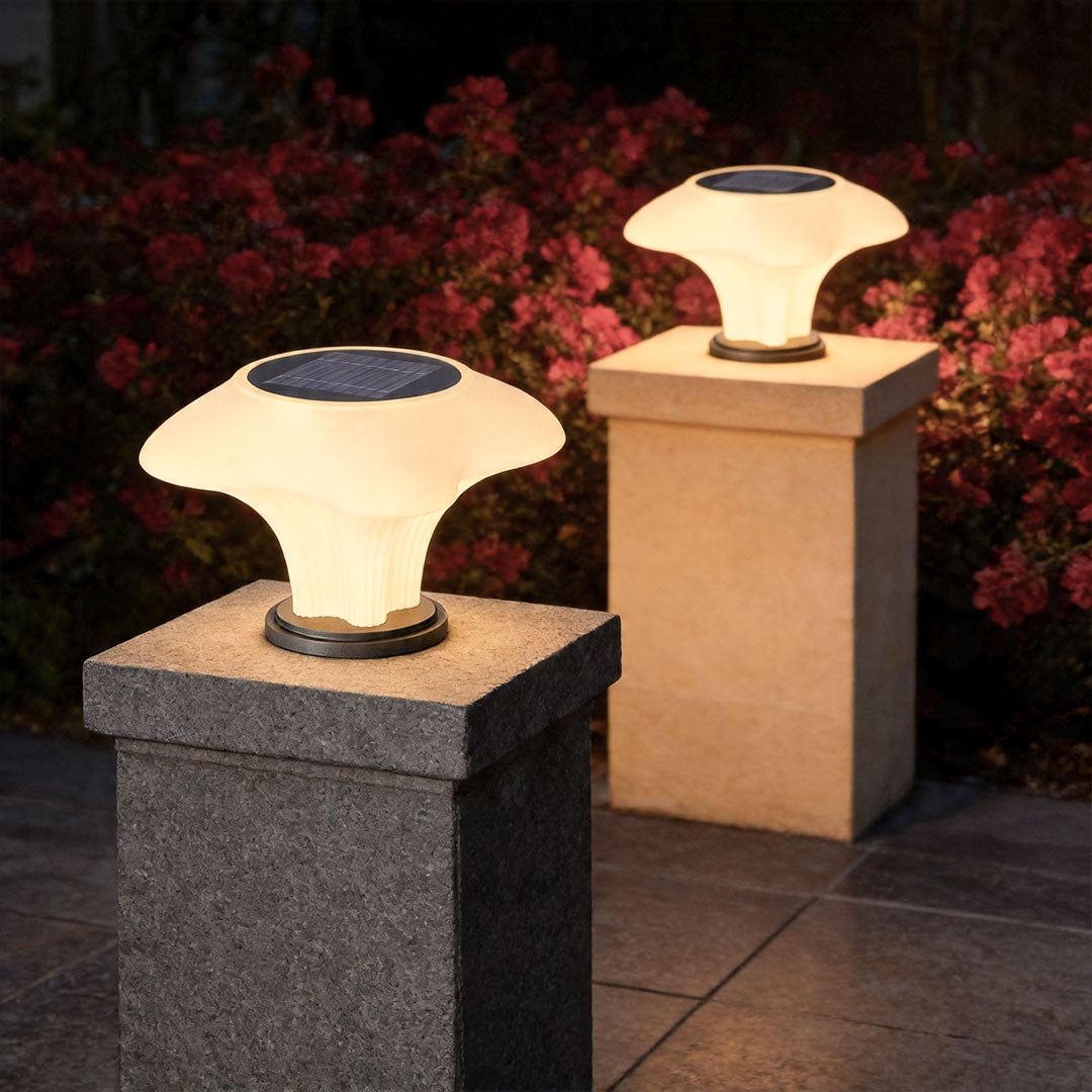 Solar pillar light illuminating modern stone pillars with decorative mushroom-shaped outdoor lighting design.