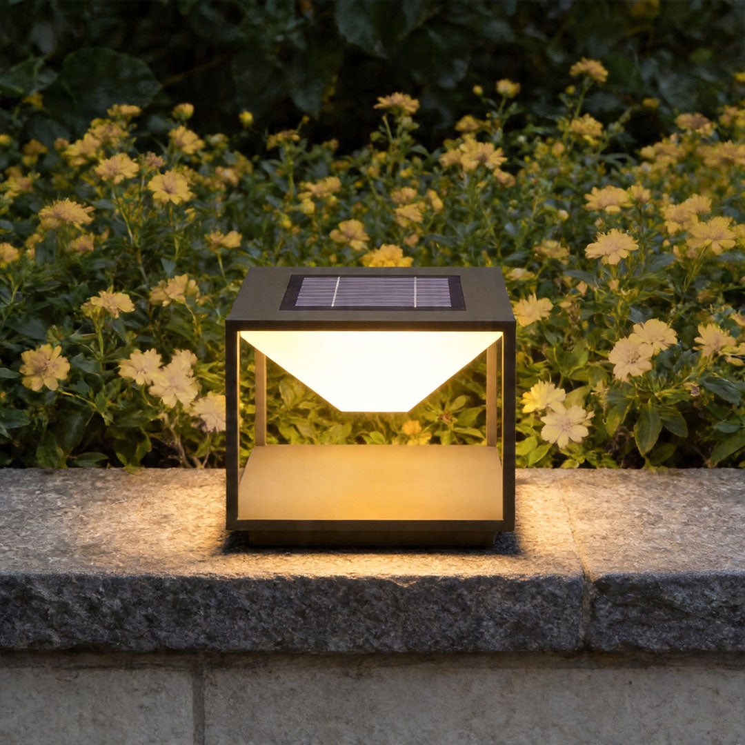 Solar pillar light outdoor installed on garden wall with warm modern landscape illumination at night.
