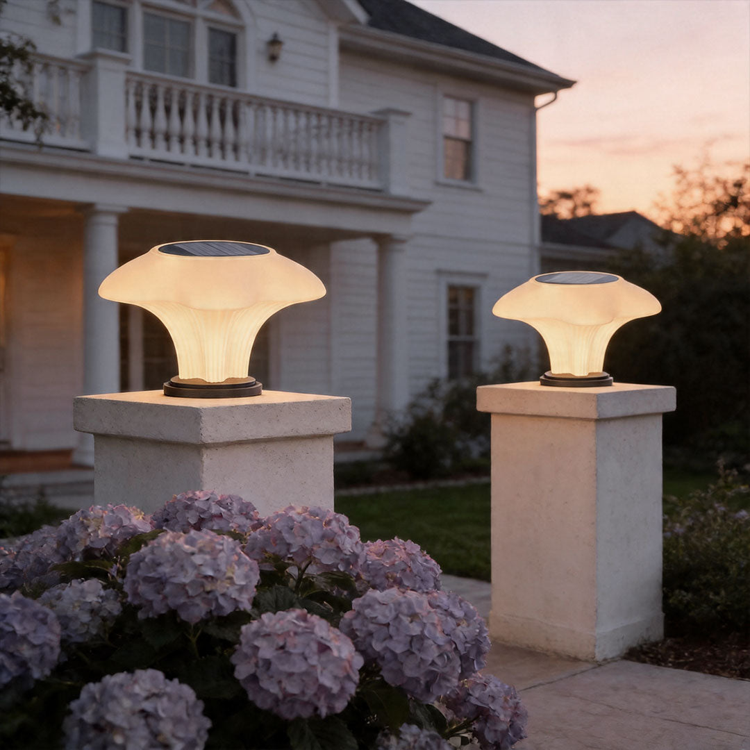 Solar pillar light on residential entrance pillars creating elegant landscape lighting at dusk.