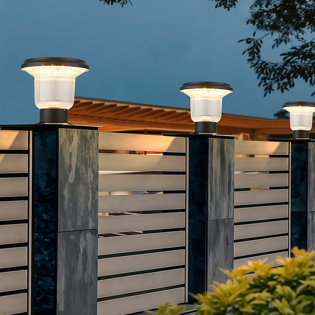 Solar-powered pillar light illuminating a stone fence, providing lighting for a cozy outdoor atmosphere.