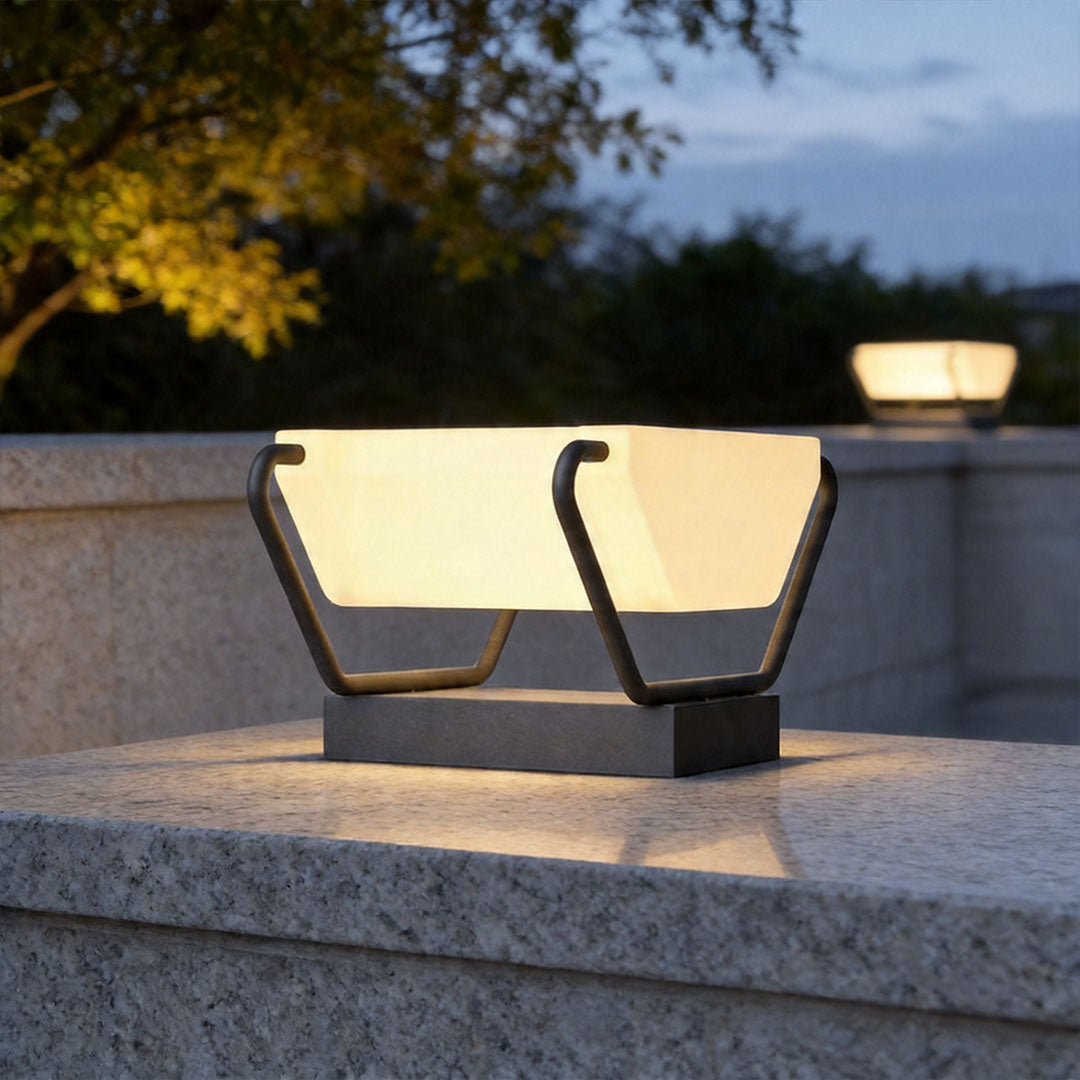 Solar pillar lighting illuminating outdoor stone wall with warm LED glow at dusk.