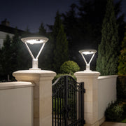 Solar pillar lights with a modern design, illuminating a garden fence at night.