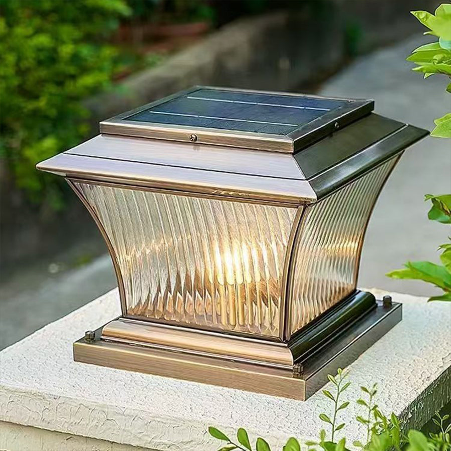 Solar-powered post cap light with ribbed glass design positioned on stone garden pillar