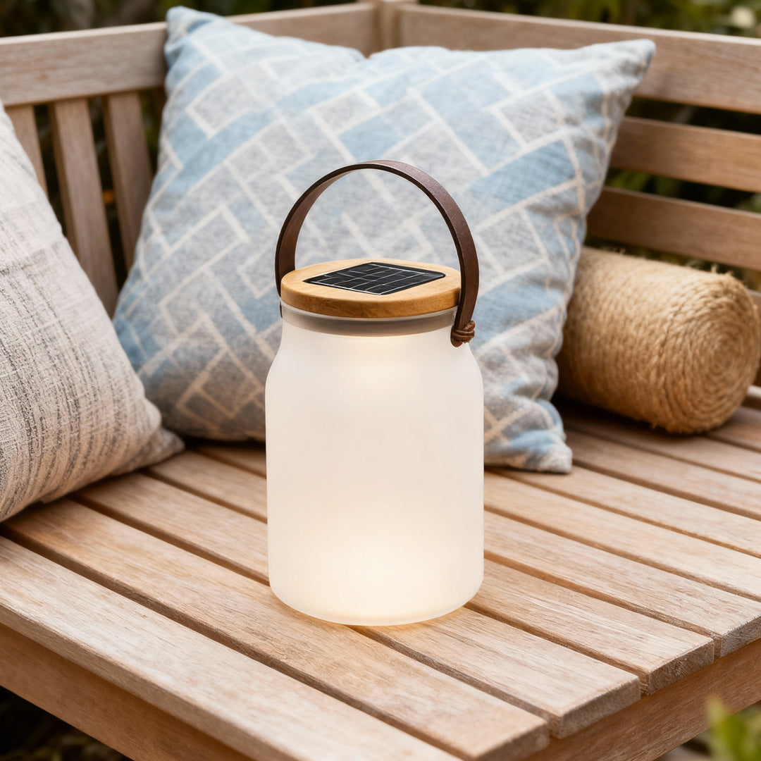 Solar powered camp lantern placed on outdoor seating, providing warm illumination for cozy camping moments.